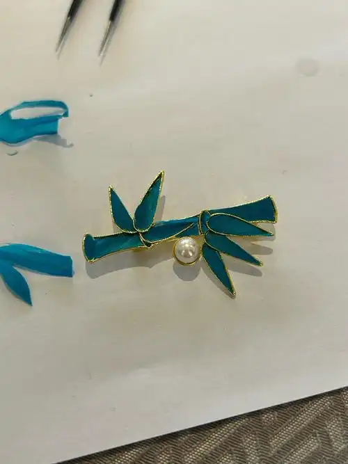点翠的核心是金属胎制作+羽料处理+“点”（铺贴羽丝）整套手工技法